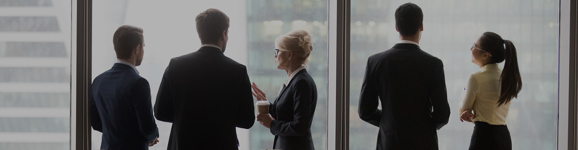 Business executives stand near at an office window discussing important matters