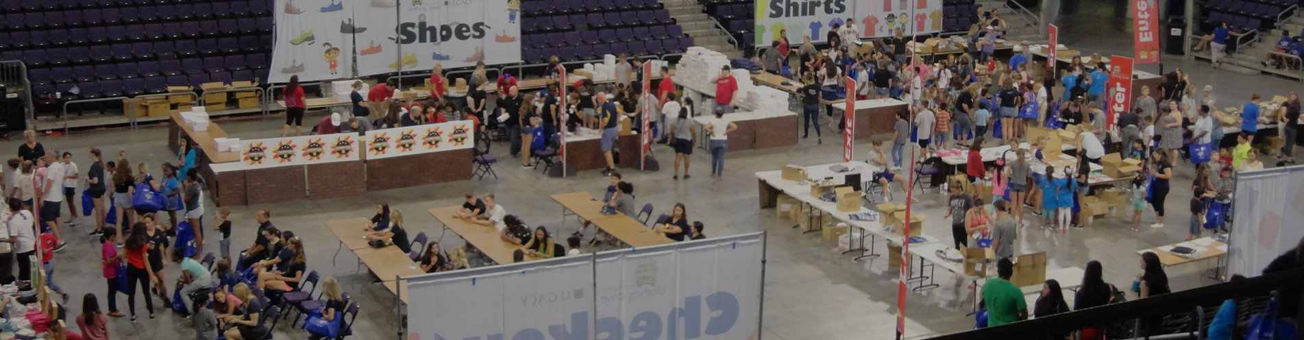 A gymnasium space fitted with tables for volunteers to perform charity work