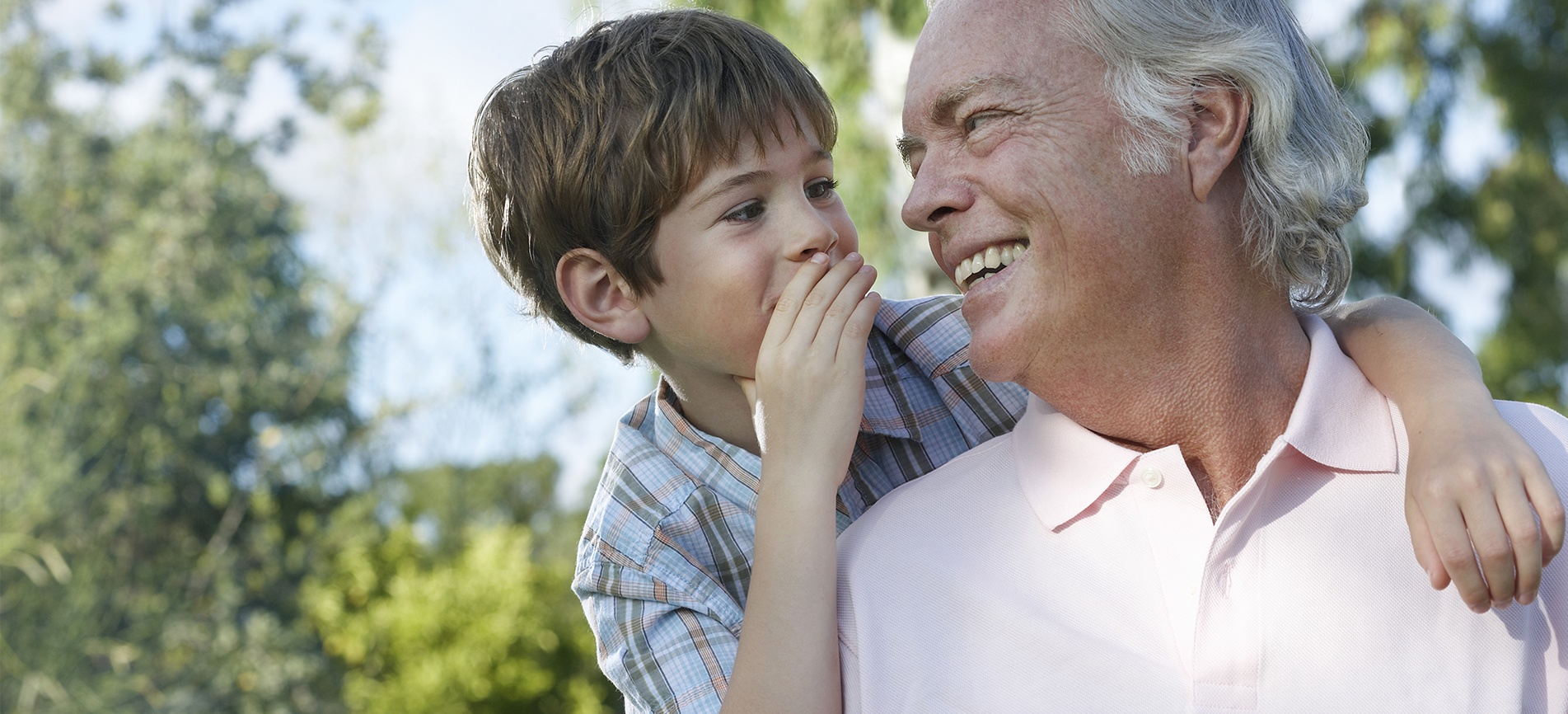 A happy grandfather and grandson bond in a lush park setting